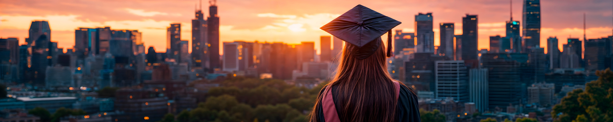 female student in cap and gown faces city view