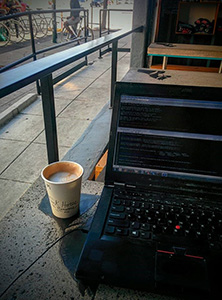 computer with cup of coffee on front porch